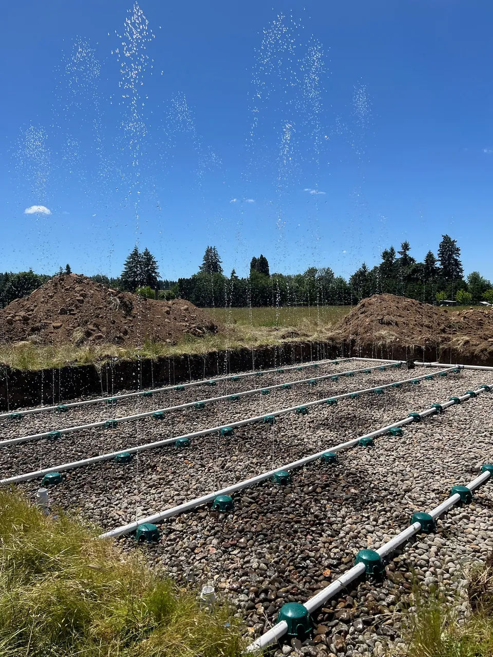 Water spraying from a distribution pipe grid during a field test