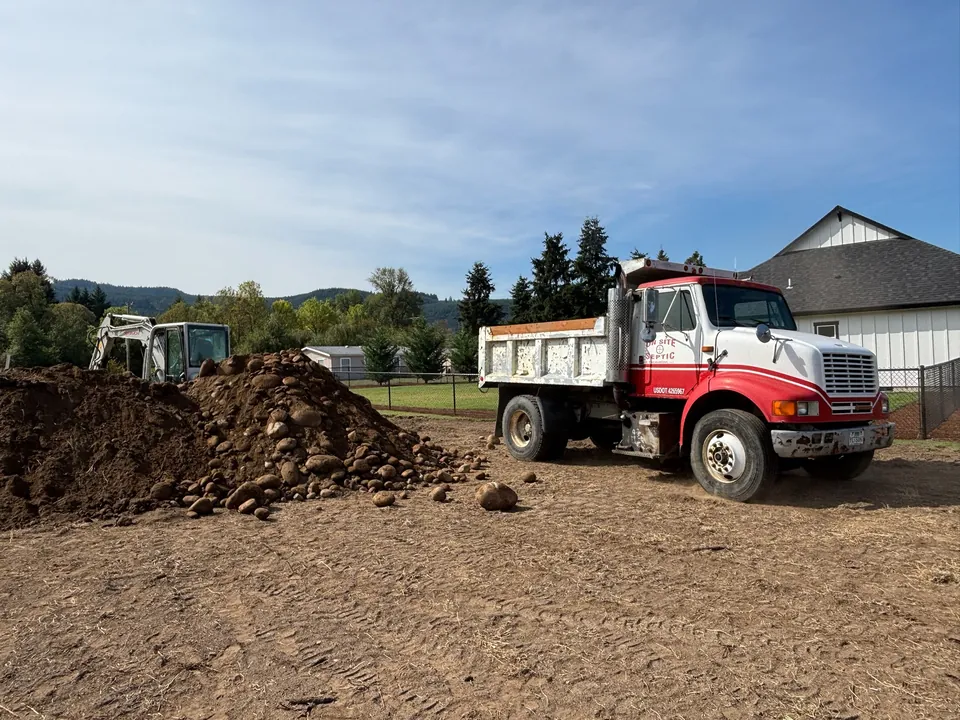 On-Site branded dump truck and excavator at an earthwork site